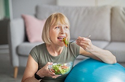 woman eating salad in home