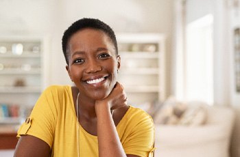 Woman with straight teeth smiling at home