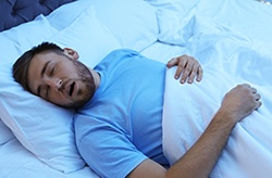Man snoring in bed