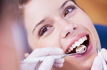 Womn receiving dental checkup and teeth cleaning