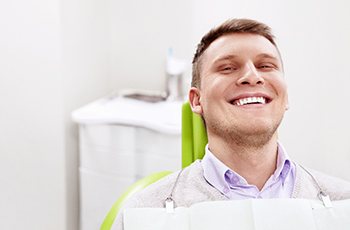 Man smiling while relaxing in dental chair