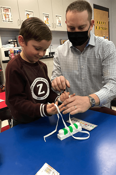 Dentist showing young patient how to floss