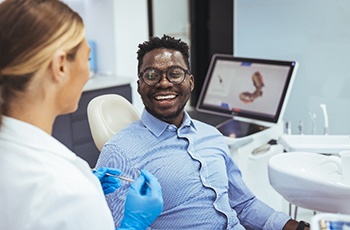 Man smiling at dentist during clear aligners consultation