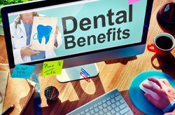 Monitor that says “Dental Benefits” on a busy desk