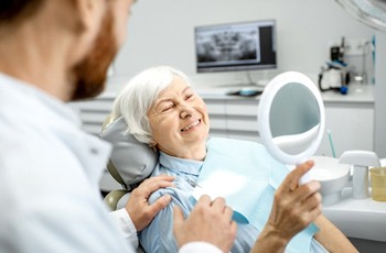 Woman admiring her new dentures in Columbia