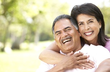 Smiling couple with dentures in Columbia outside