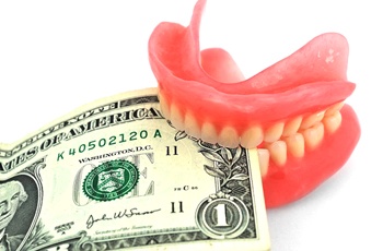 Dentures holding money representing cost of dentures in Columbia