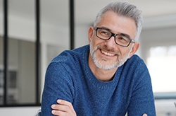 man smiling with arms crossed