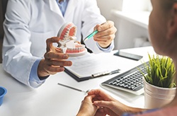 a dentist holding a model of dentures