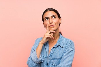 Woman looking up and thinking about emergency dentistry in Columbia