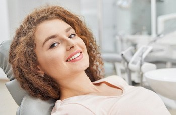 Female dental patient smiling and leaning back in chair