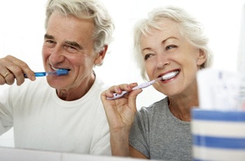 elderly couple brushing their teeth together