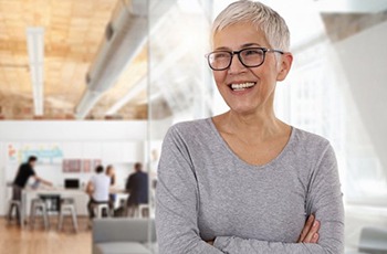 smiling woman standing with her arms crossed
