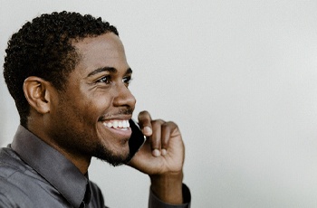 person smiling and talking on the phone