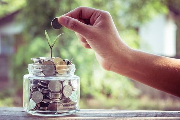 hand putting coin in bank