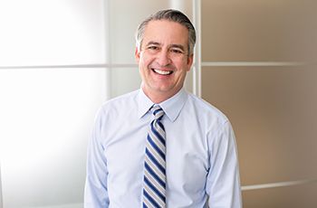 man in dress shirt and tie smiling after periodontal therapy in Columbia