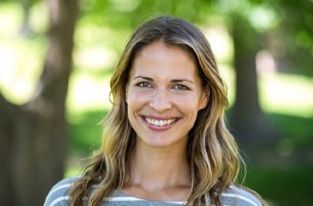 young woman smiling in dental chair after periodontal therapy