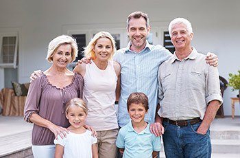 Large family smiling together outdoors after family dentistry visit