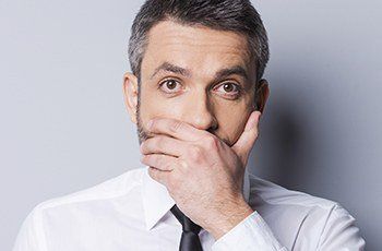 Man covering mouth before root canal therapy