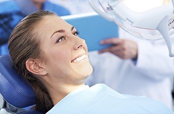 Smiling woman in dental chair for tooth extractions