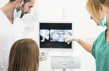 Dentist and patient looking at x-rays after bone graft procedure