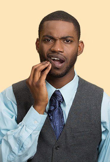 Man holding the side of his jaw in pain