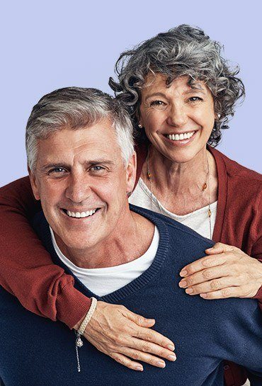 Older man and woman smiling and hugging