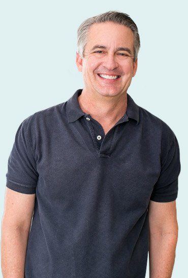 Smiling man in black polo shirt