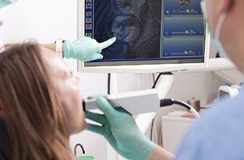 Patient and dentist looking at intraoral photos