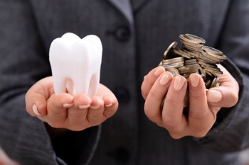 Hands holding tooth and coins