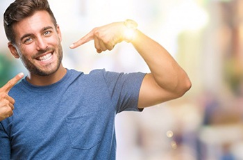 Man pointing to his smile after porcelain veneers