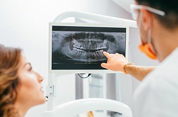 Dentist and patient looking at digital x-rays