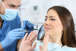 Womin in dental chair talking to dentist