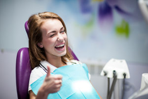 woman smiling and winking in dental chair