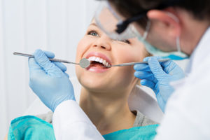 woman in dental chair talking to dentist