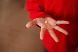 A person holding a knocked-out tooth.