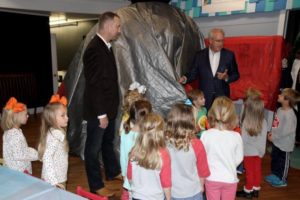 Dentists about to unveil their exhibit to a group of children.