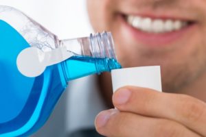 Closeup of man pouring blue mouthwash 