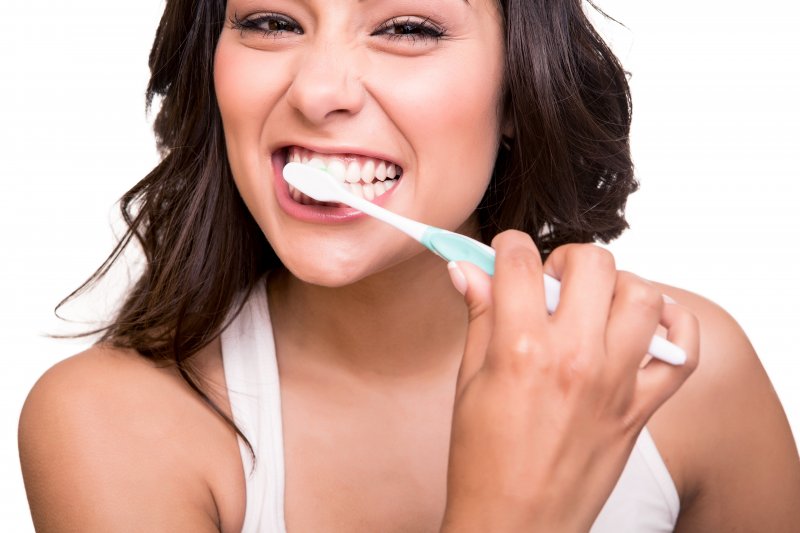 woman brushing teeth as instructed by family dentist in Columbia