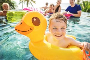 Boy with innertube in pool smiles after seeing his Columbia dentist