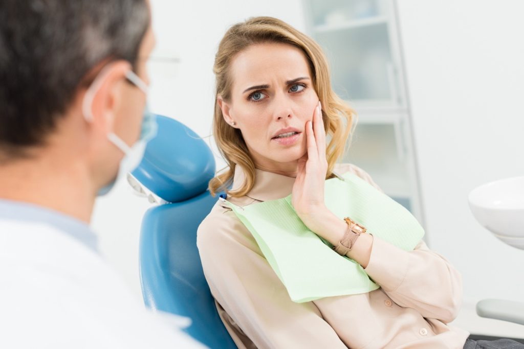 Woman visiting the dentist for a dental emergency.