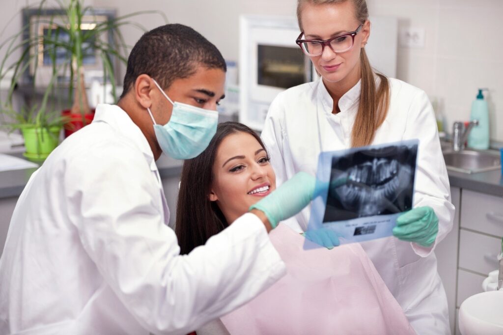 dentists showing patient dental X-rays