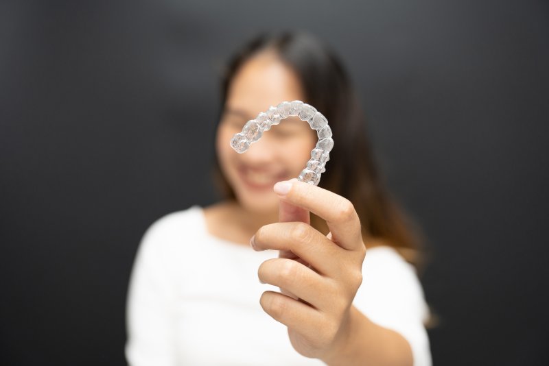 A woman holding up a professional clear aligner