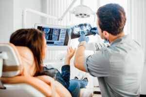 Dentist pointing to his patient's X-rays 