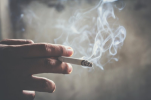 Man holding a cigarette between two fingers
