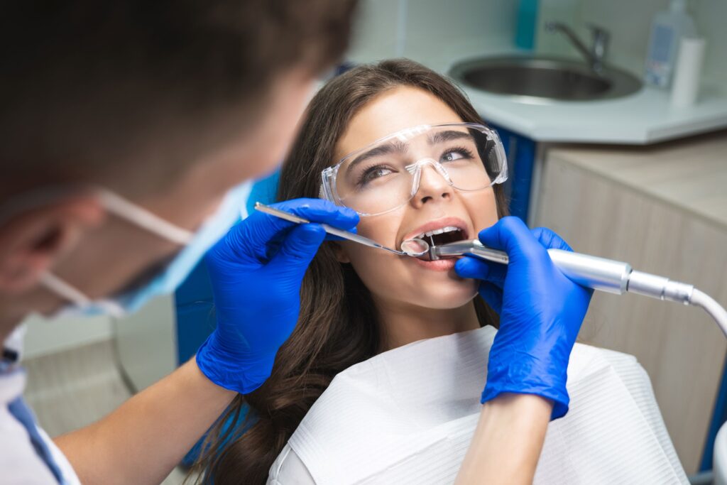 Woman with brown hair looking at dentist as she undergoes root canal