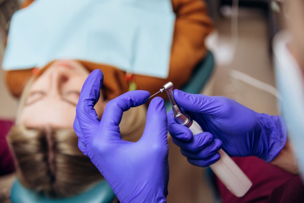 Gloved hands preparing root canal instrument for patient's procedure