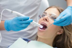 Dentist using intraoral camera to examine patient.