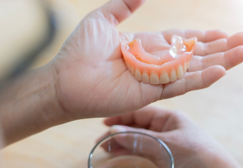 Hand holding dentures